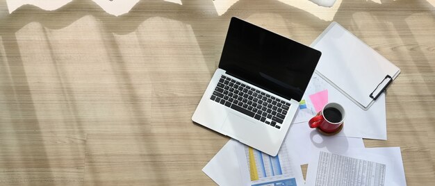 Un computer portatile con schermo vuoto sta mettendo sul pavimento di legno a casa.