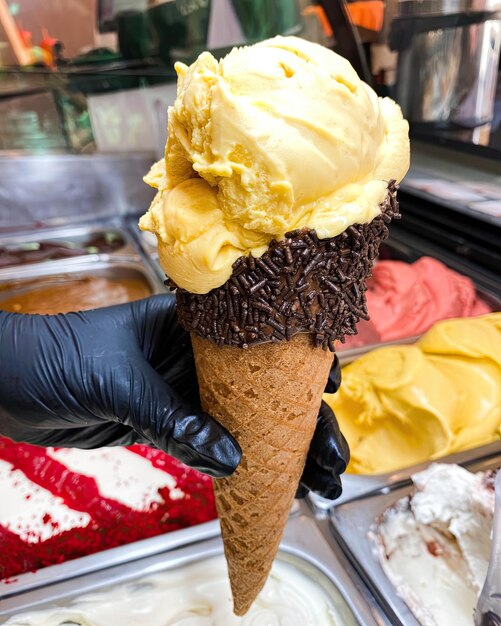 Un cono di gelato è tenuto da una persona che indossa un guanto.