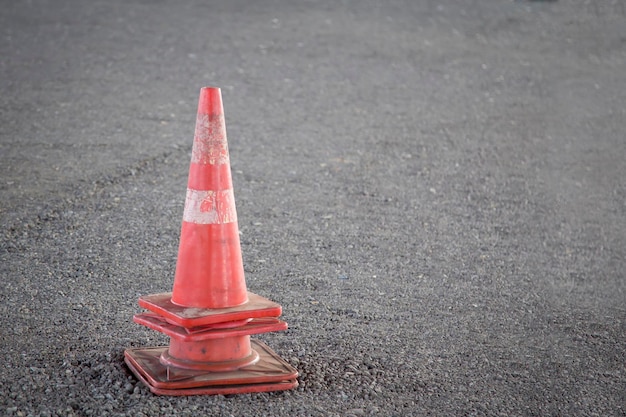 Un cono stradale rosso si trova nel mezzo di una strada