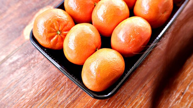 Un contenitore nero di arance su un tavolo