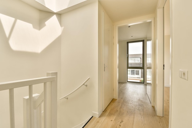 un corridoio con pareti bianche e pavimenti in legno e un