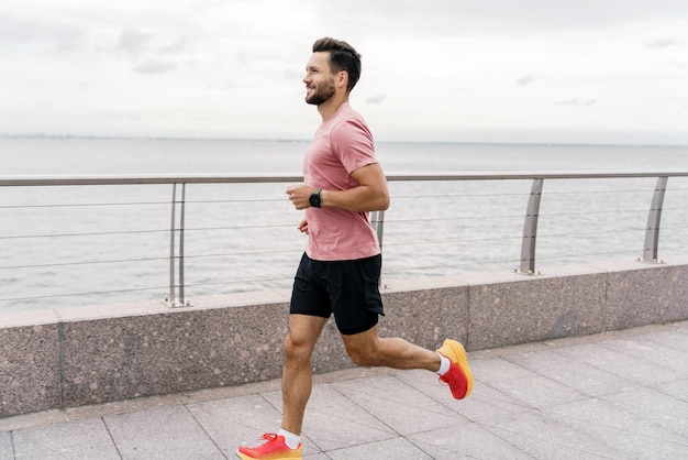 Un corridore che utilizza uno smartwatch per abbigliamento sportivo da fitness e scarpe da corsa Tavola da allenamento per atleta