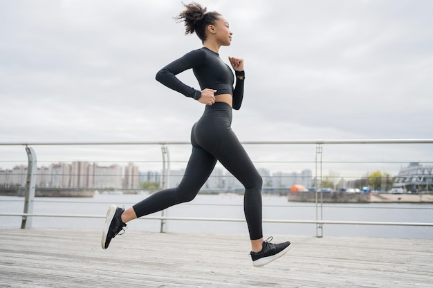 Un corridore femminile sta eseguendo un allenamento fitness in una tuta attillata