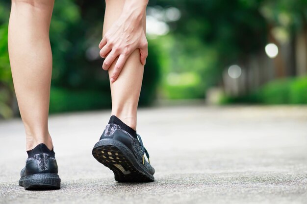 Un corridore ha molto dolore alle gambe al parco.