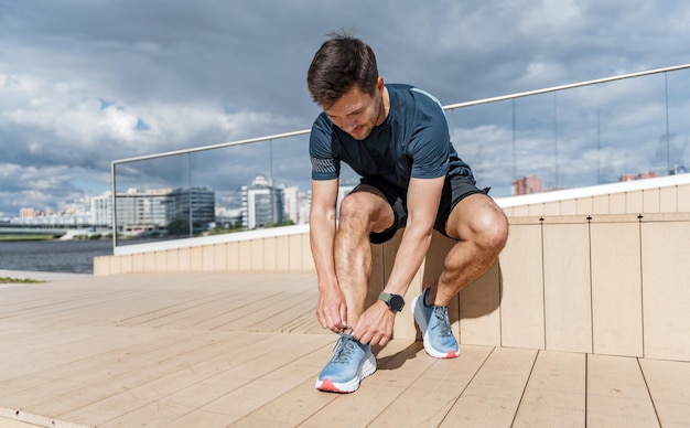 Un corridore indossa scarpe da corsa un uomo che si allena usa un orologio fitness sul braccio