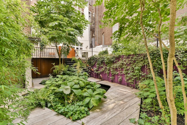 Un cortile con un ponte di legno e alberi e piante