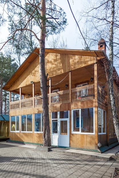 Un cottage in legno a due piani per turisti in un centro ricreativo con balcone aperto e grandi finestre