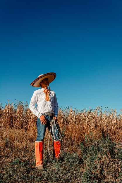 Un cowboy nella vasta prateria che brandisce il suo laccio in mezzo a un raccolto abbondante