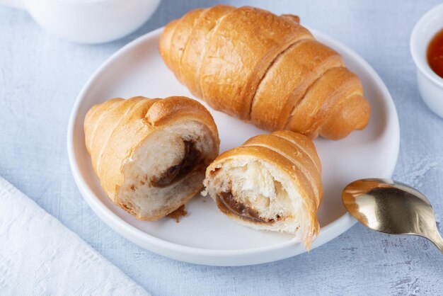 Un croissant francese appena sfornato caffè e marmellata