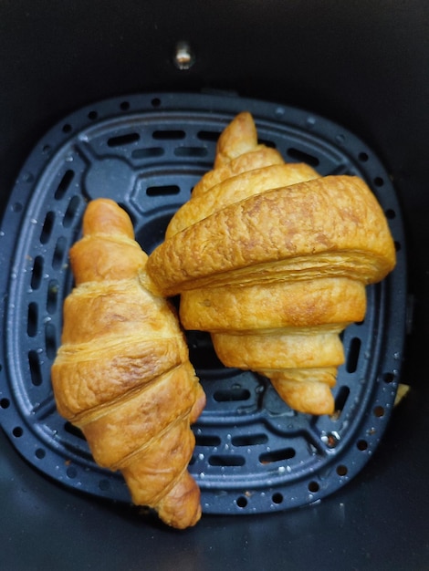 Un croissant viene cotto in una friggitrice ad aria.