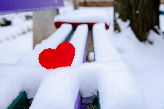 Un cuore di vimini di rosso nella neve con posto per il testo