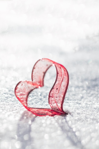 Un cuore rosso giace nella neve