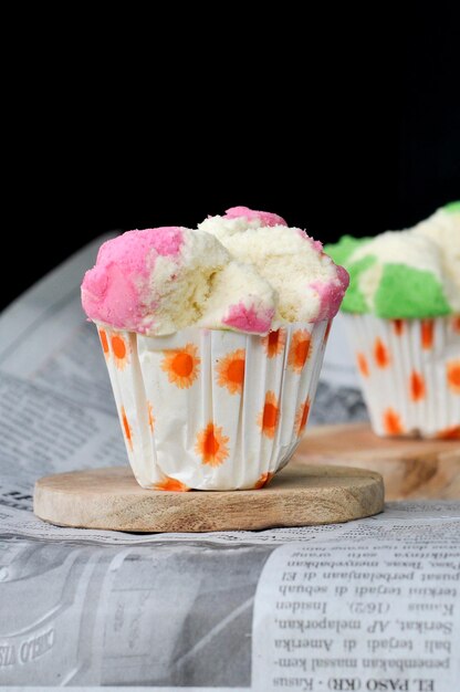 un cupcake con glassa rosa e verde e glassa bianca.