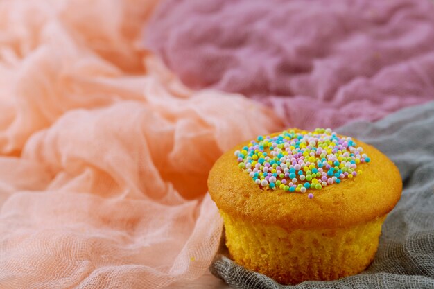 Un cupcake con spruzzi di colore sul tessuto.