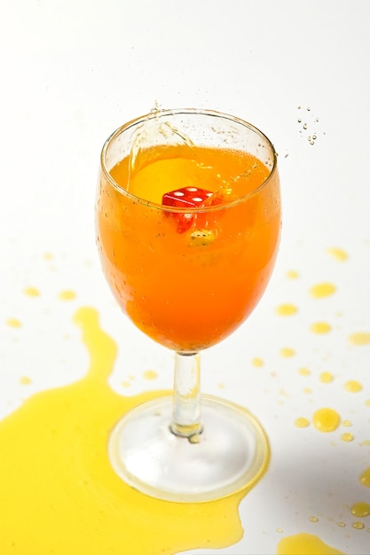 Un dado caduto in un bicchiere di liquido arancione ha causato uno splash