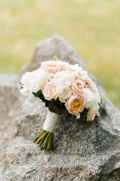 Un delicato bouquet da sposa giace su una pietra