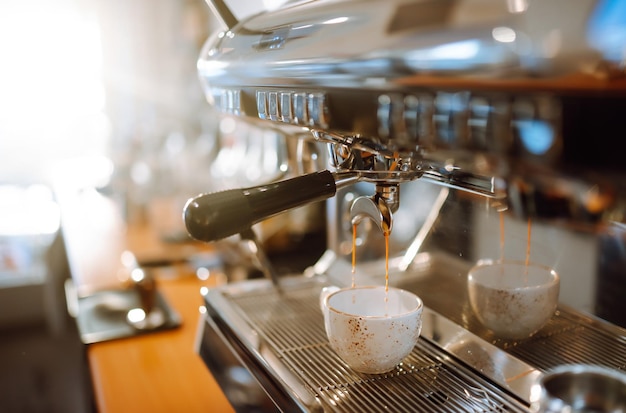 Un delizioso caffè caldo che si versa dalla macchina del caffè nella tazza del caffè