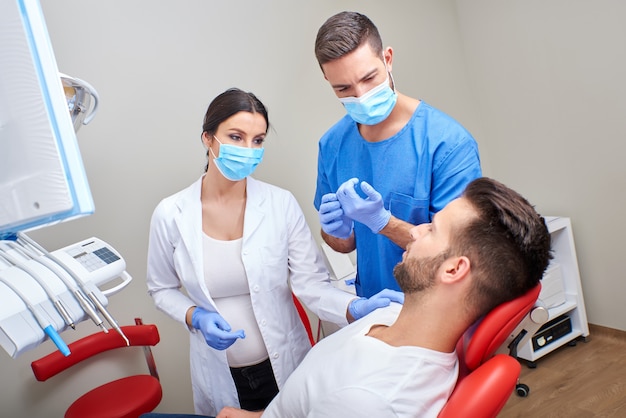 Un dentista e un assistente con il paziente