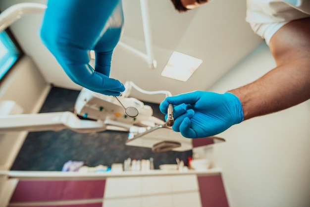 Un dentista esamina un paziente in un moderno studio dentistico con strumenti dentali. Foto di alta qualità