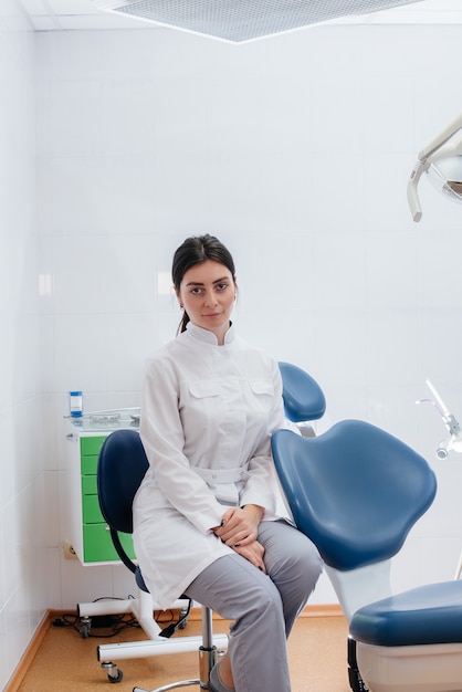 Un dentista professionista si trova in un moderno studio dentistico leggero. Odontoiatria.