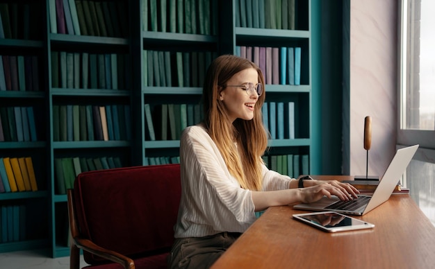 Un designer di ufficio moderno che utilizza Internet online lavorando a un progetto di avvio Una donna con gli occhiali