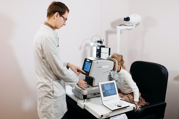 Un dottore e un bambino stanno lavorando su un microscopio guardando un esame della vista con un dottore