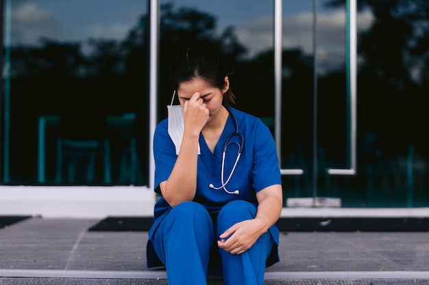 Un dottore preoccupato e stressato seduto nel corridoio.