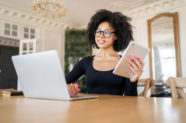 Un'economista freelance, una donna con gli occhiali lavora, usa un laptop in ufficio fa una relazione con i documenti in una società finanziaria