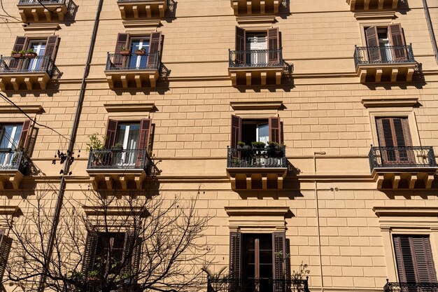 Un edificio alto con molte finestre e balconi