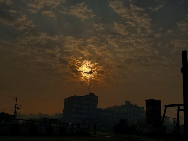 Un edificio con il sole che tramonta dietro di esso