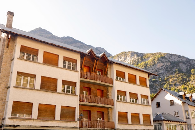 un edificio con un balcone che ha una montagna sullo sfondo.