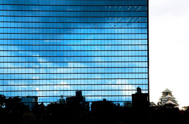 Un edificio con un cielo blu nella riflessione.