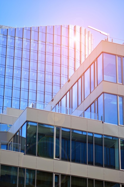 un edificio con una facciata in vetro e il sole che filtra dalle finestre.