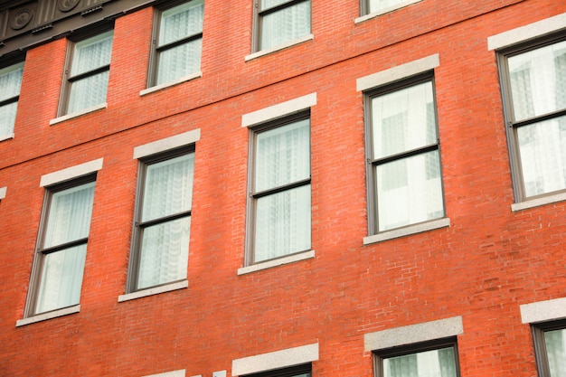 Un edificio di mattoni rossi con una serie di finestre sulla facciata.