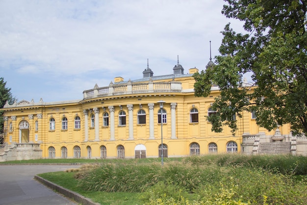 Un edificio giallo con una grande finestra che dice "palazzo".