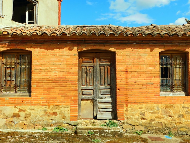 Un edificio in mattoni con porta e finestre in legno con tetto in tegole.