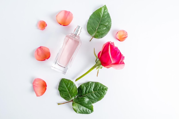 Un'elegante bottiglia di profumo femminile o profumo spray su uno sfondo bianco tra i petali e il bocciolo di rose flacone piatto senza nome
