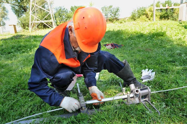 Un elettricista attorciglia i cavi elettrici utilizzando attrezzature speciali