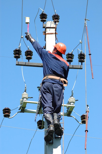 Un elettricista misura la tensione su una linea elettrica prima di installare la messa a terra.