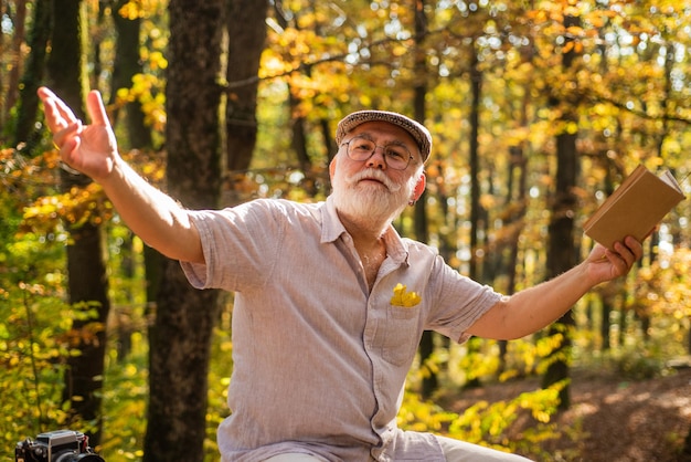 È un'enciclopedia ambulante. L'uomo anziano tiene il libro in natura. Il pensionato ha letto il libro il giorno d'autunno. Tempo libero per la lettura. Vecchio topo di biblioteca. Diario di viaggio. Non posso vivere senza libro.