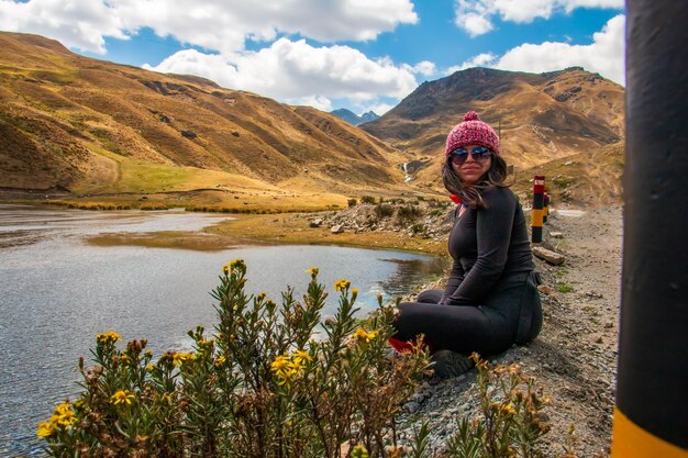 Un escursionista in posa vicino a un lago ai piedi della nevosa Raura Oyon Perù