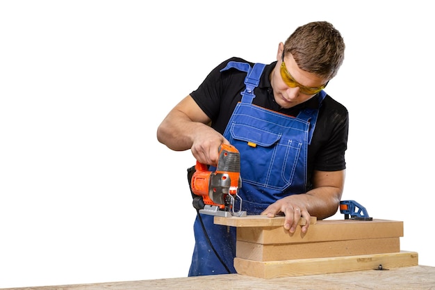 Un falegname che usa un puzzle per tagliare il legno taglia barre su uno sfondo bianco Concetti di riparazione domestica da vicino