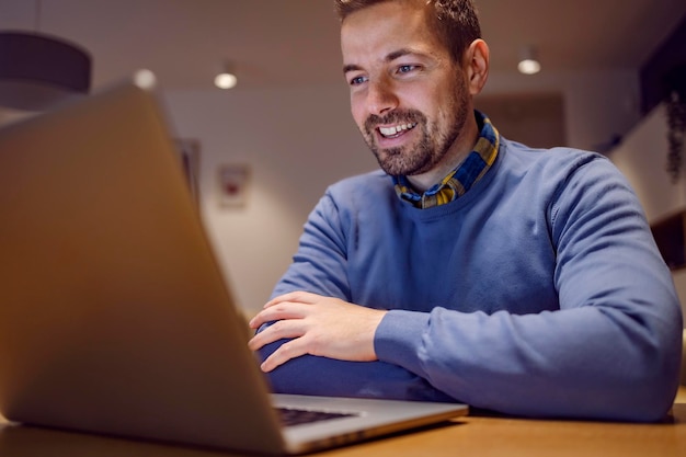 Un felice imprenditore che guarda il laptop e lavora da casa