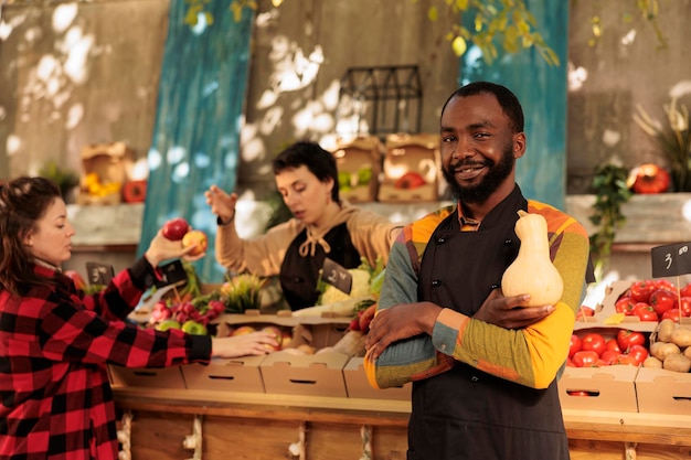Un felice venditore afroamericano che si prepara a vendere cibo biologico.