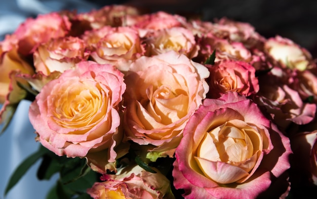 Un festoso bouquet di rose arancioni alla luce del sole. Sfondo floreale