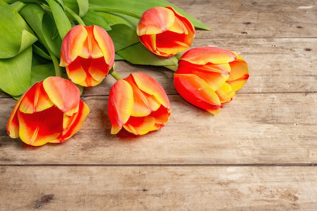 Un festoso bouquet di tulipani freschi su un tavolo di legno vintage