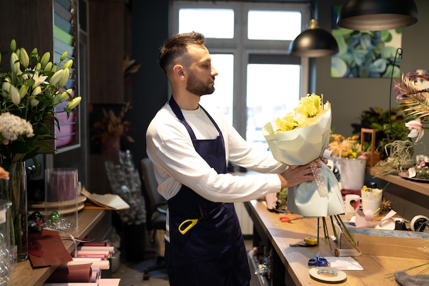 Un fiorista di talento assembla un bouquet di rose firmate di alta qualità