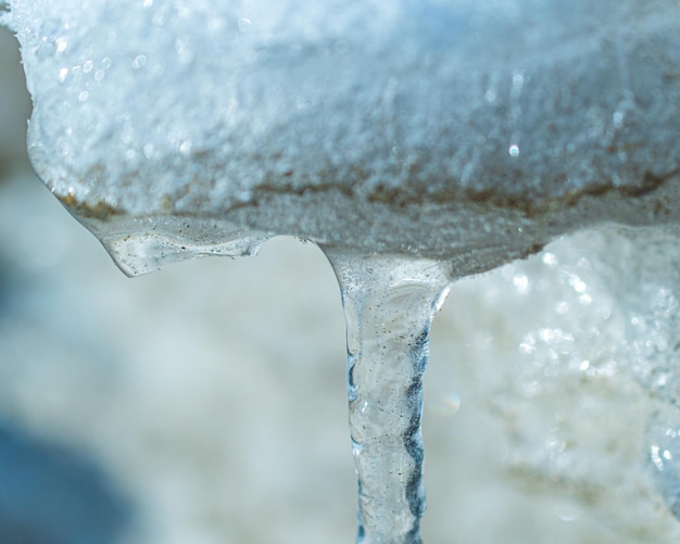 Un flusso di acqua ghiacciata gocciola da un pezzo di ghiaccio.