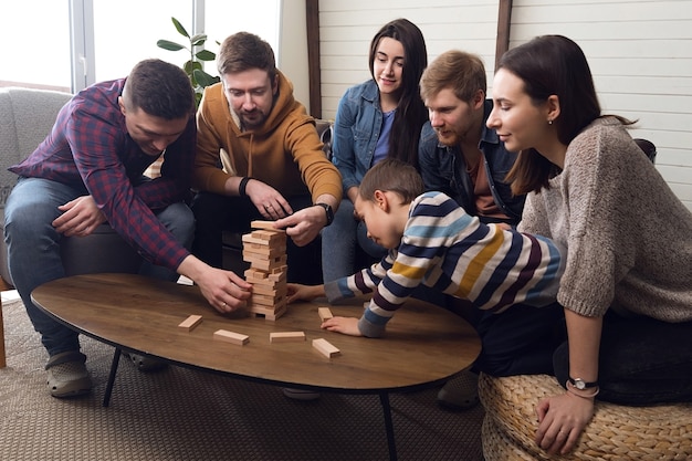 Un folto gruppo di amici gioca a giochi da tavolo, una allegra compagnia a casa. Foto di alta qualità