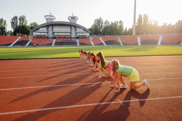 Un folto gruppo di ragazze si è preparato alla partenza prima di correre allo stadio durante il tramonto Uno stile di vita sano